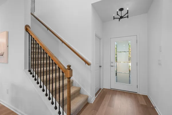 a view of a hallway with wooden floor and staircase