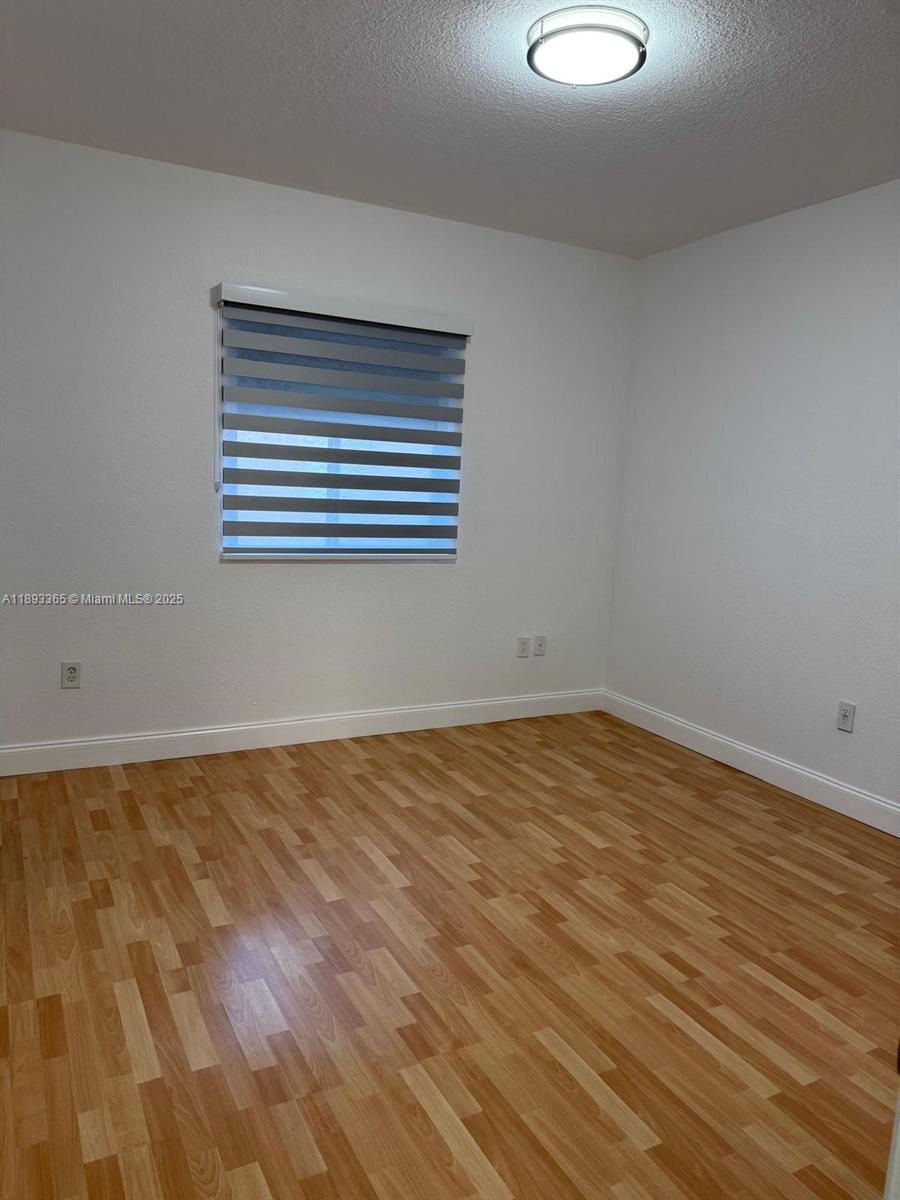 7221 Northwest 174th Terrace, Unit 202 Hialeah, FL 33015 - Photo 12 of 15 a view of empty room with wooden floor