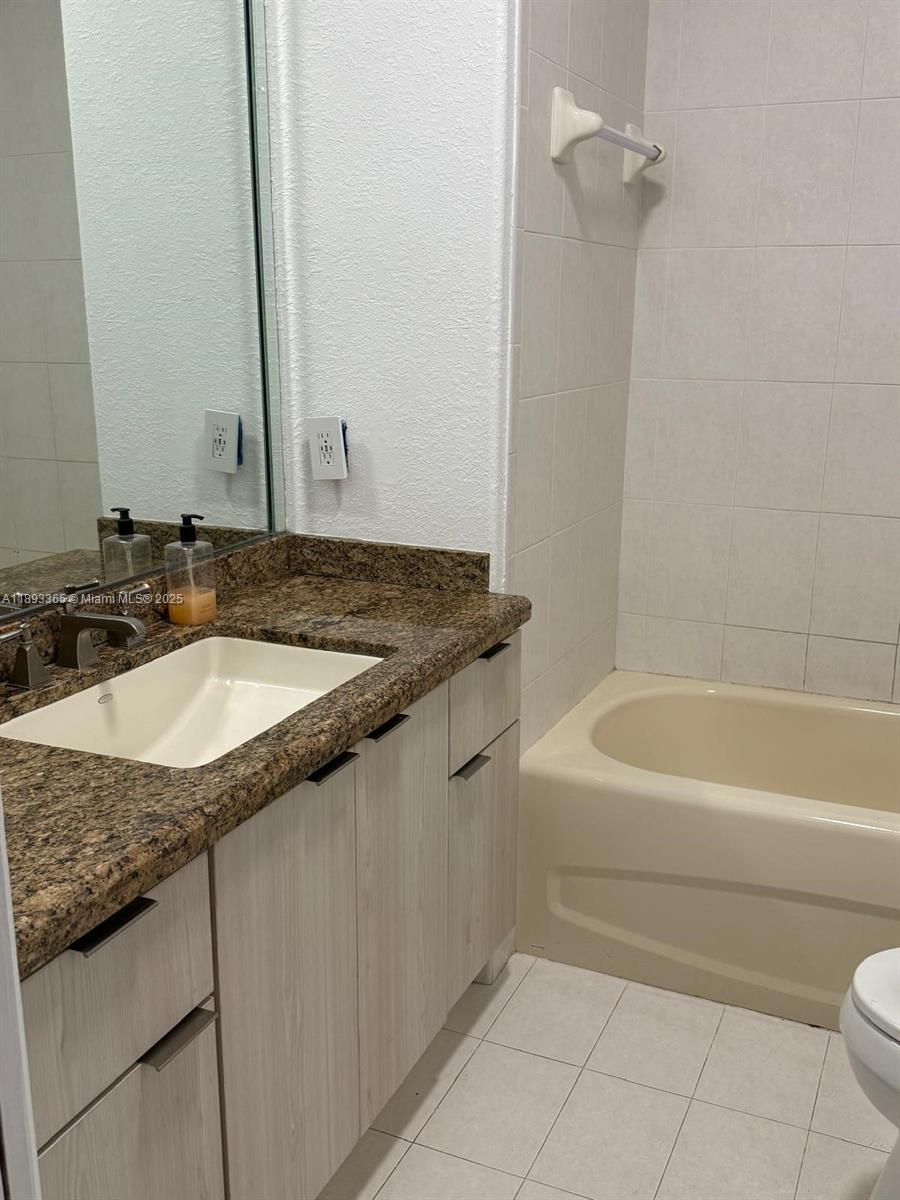 7221 Northwest 174th Terrace, Unit 202 Hialeah, FL 33015 - Photo 13 of 15 a bathroom with a granite countertop sink and a mirror