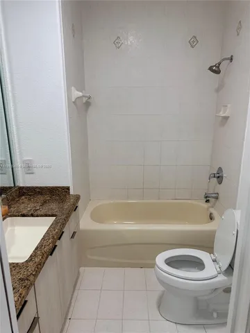 a bathroom with a granite countertop toilet a sink and bathtub