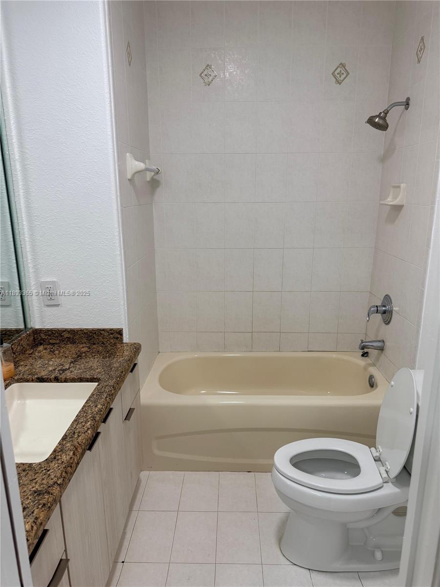 7221 Northwest 174th Terrace, Unit 202 Hialeah, FL 33015 - Photo 14 of 15 a bathroom with a granite countertop toilet a sink and bathtub