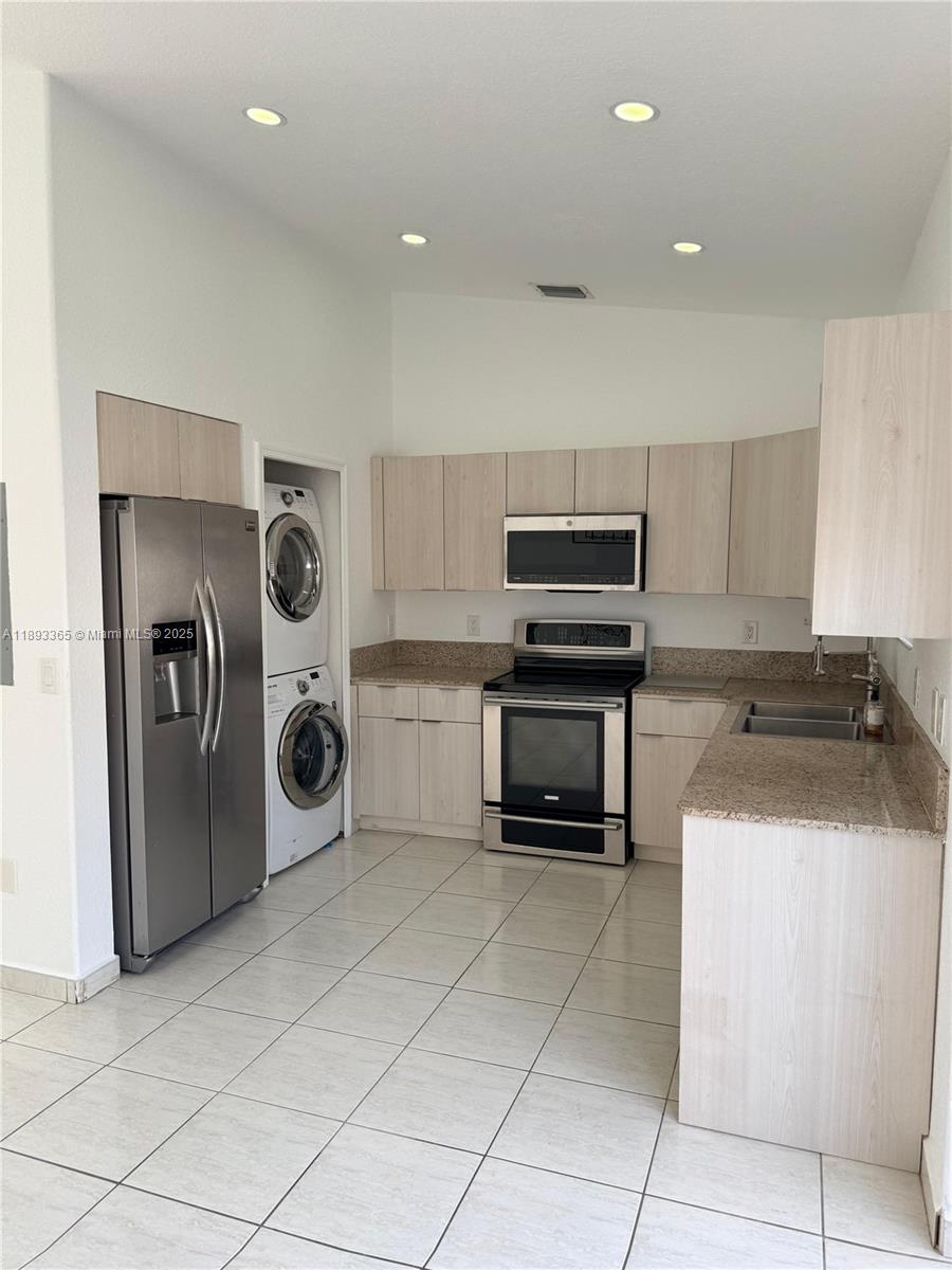 7221 Northwest 174th Terrace, Unit 202 Hialeah, FL 33015 - Photo 6 of 15 a kitchen with a stove top oven and cabinets