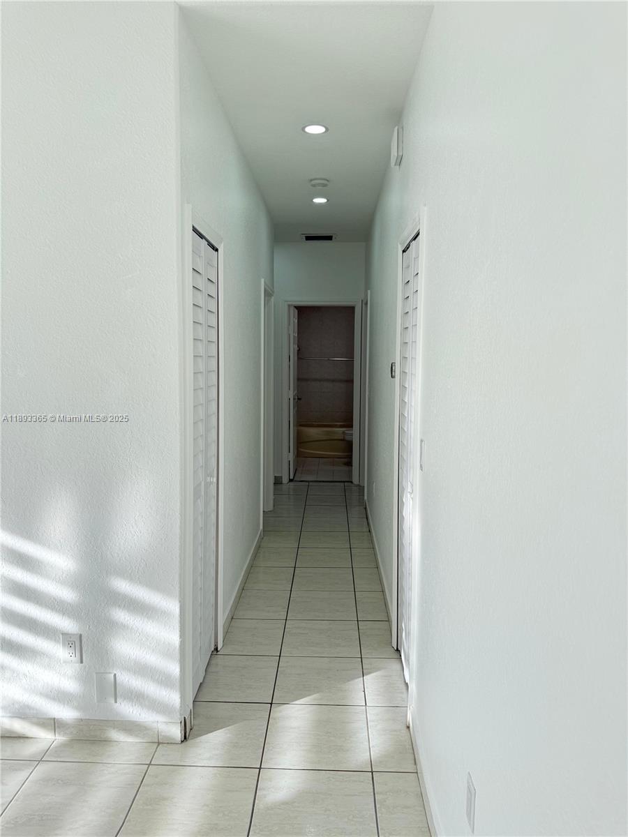 7221 Northwest 174th Terrace, Unit 202 Hialeah, FL 33015 - Photo 9 of 15 a view of a hallway with a shower