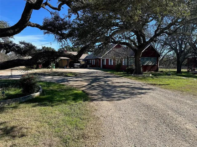 a yellow house with trees in front of it