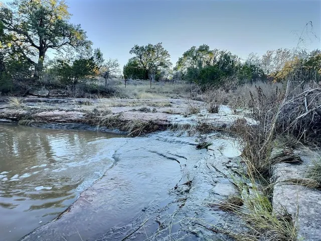 a view of a lake with beach and trees