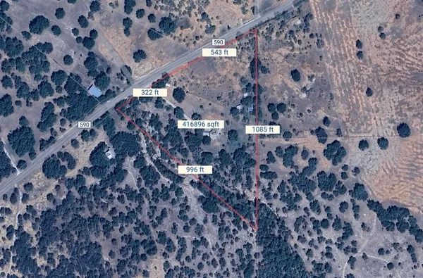 a aerial view of a house with a yard and large trees