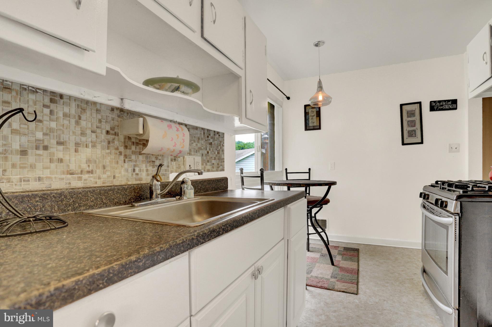 201 Belton Road Silver Spring, MD 20901 - Photo 8 of 24 a kitchen with stainless steel appliances granite countertop a sink a stove and a refrigerator with wooden floor