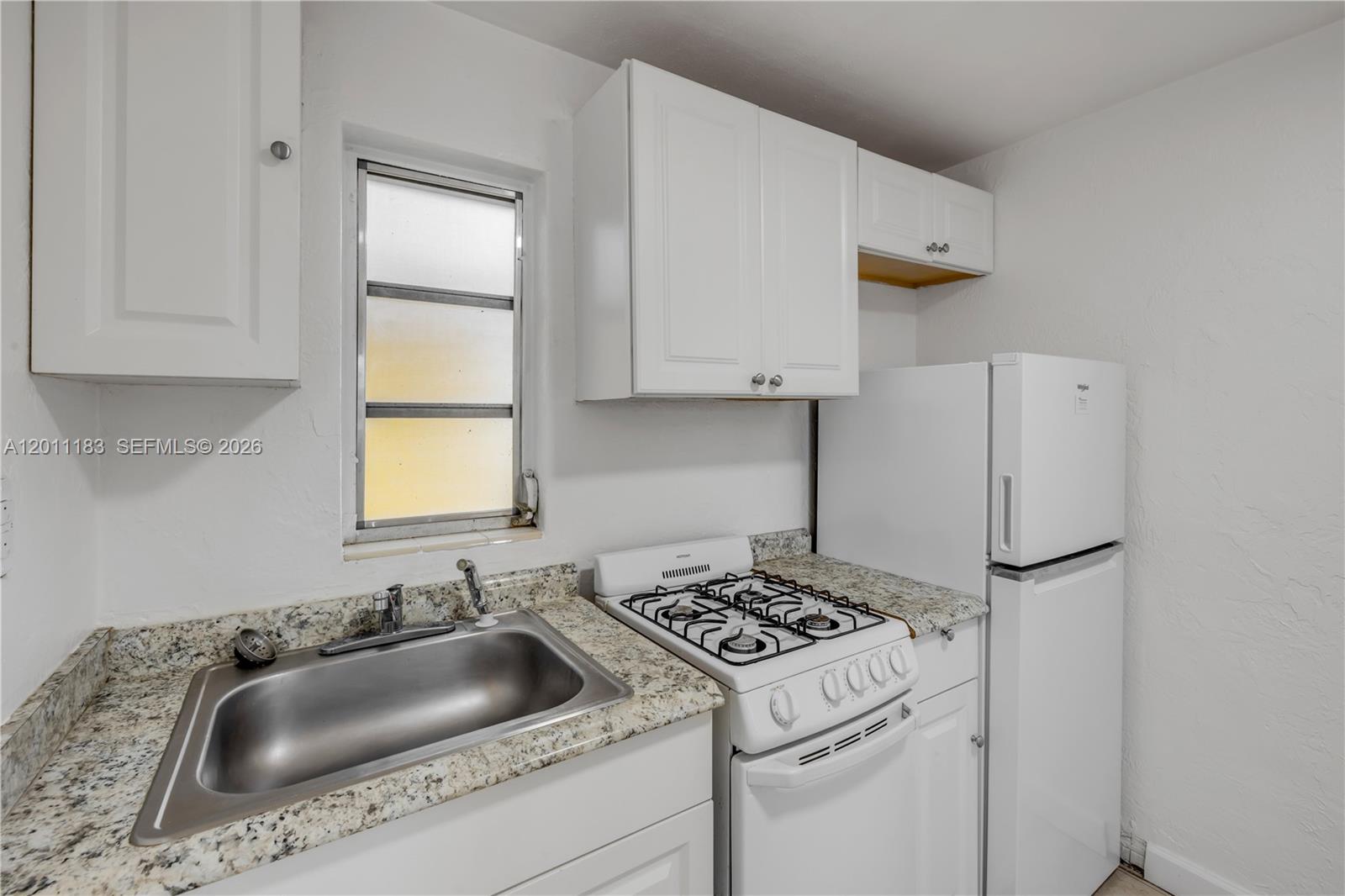 1208 South Ridgewood Avenue Daytona Beach, FL 32114 - Photo 11 of 27 a kitchen with a sink cabinets and a stove