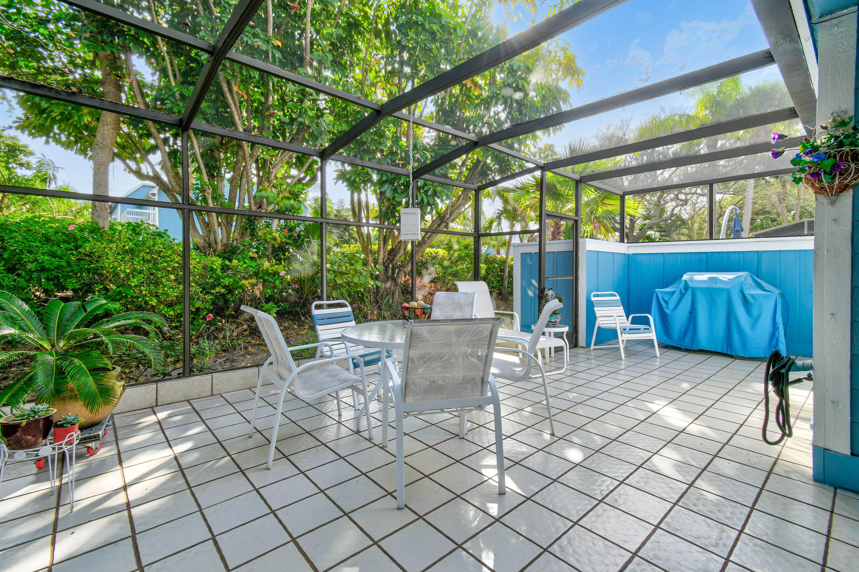 607 Ocean Dunes Circle Jupiter, FL 33477 - Photo 24 of 45 a view of a patio with table and chairs potted plants and large tree