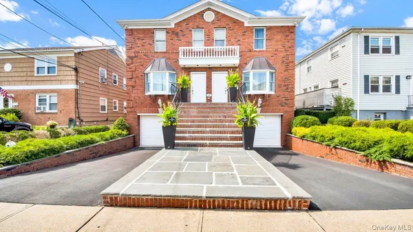 a front view of a house with a yard and potted plants