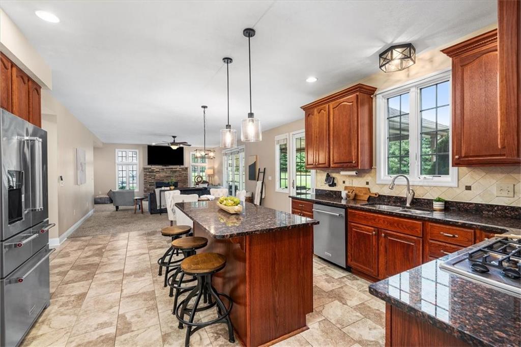 185 Pinkerton Road Wexford, PA 15090 - Photo 9 of 40 a kitchen with stainless steel appliances granite countertop a stove top oven a sink dishwasher a dining table and chairs with wooden floor