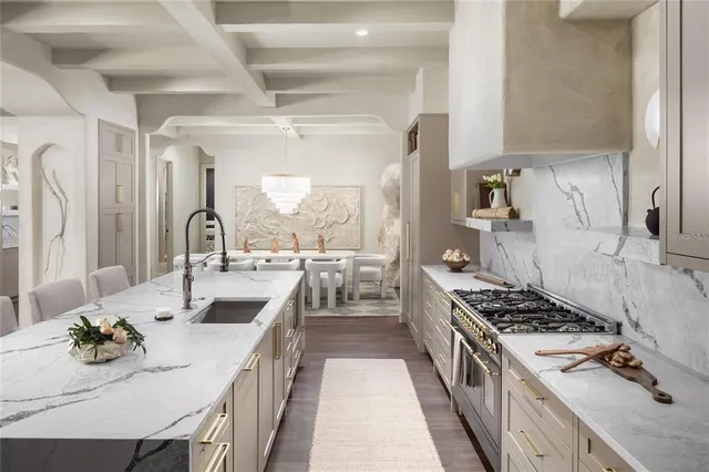 a kitchen with kitchen island stainless steel appliances a sink stove and table