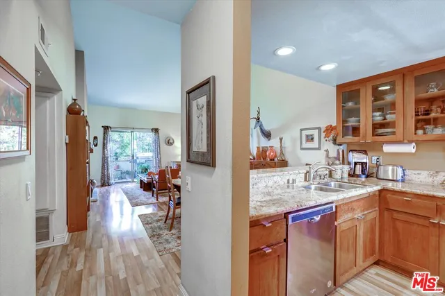 a very nice looking kitchen with granite countertop a large counter top space and stainless steel appliances