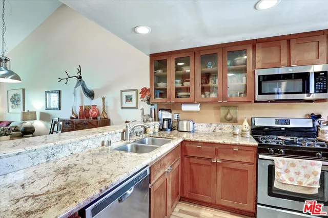 a kitchen with stainless steel appliances granite countertop a sink stove and microwave