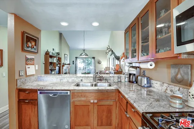 a kitchen with stainless steel appliances granite countertop a sink and a refrigerator