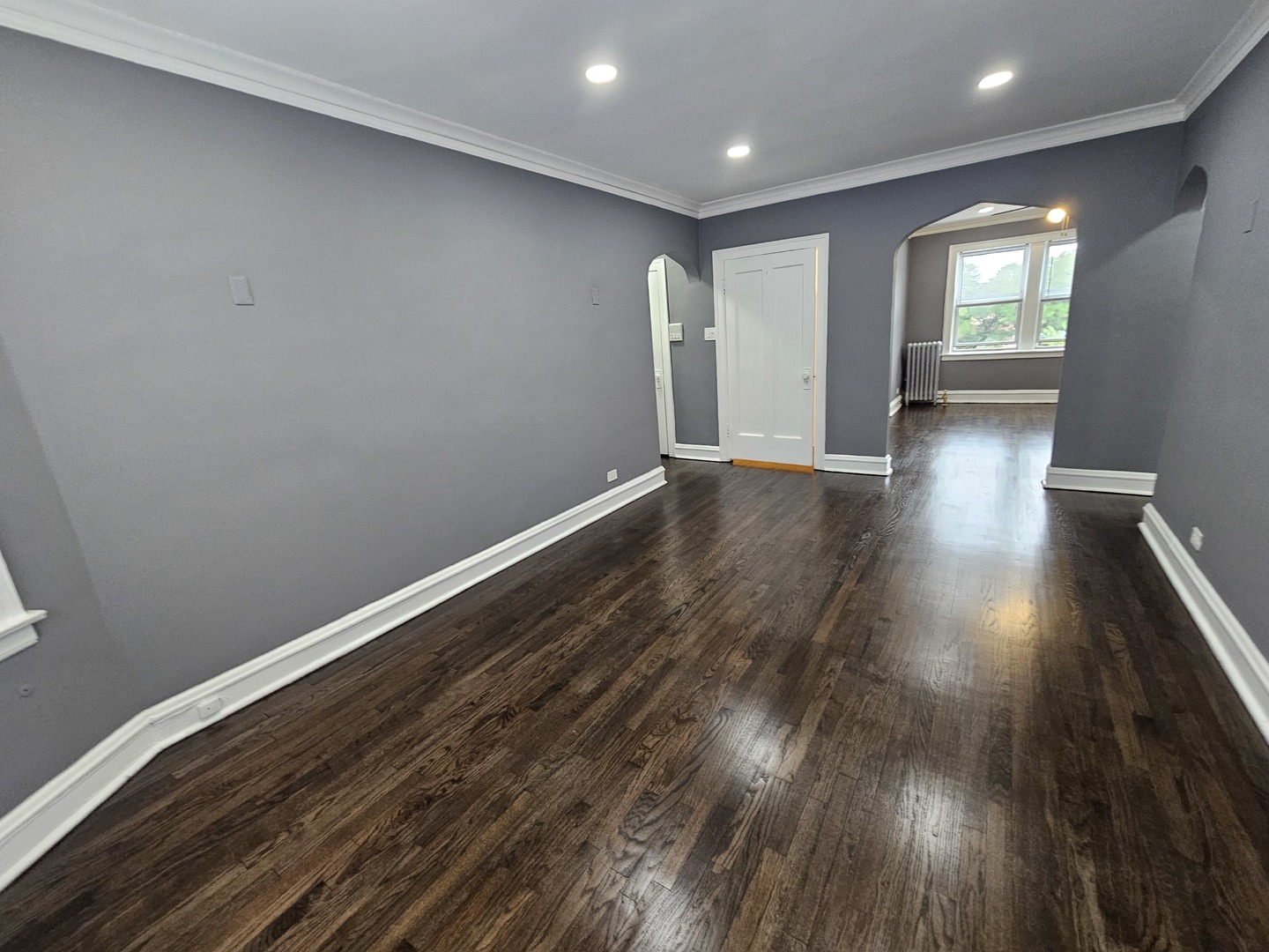 6551 North Francisco Avenue, Unit 3B Chicago, IL 60645 - Photo 3 of 15 an empty room with wooden floor and windows