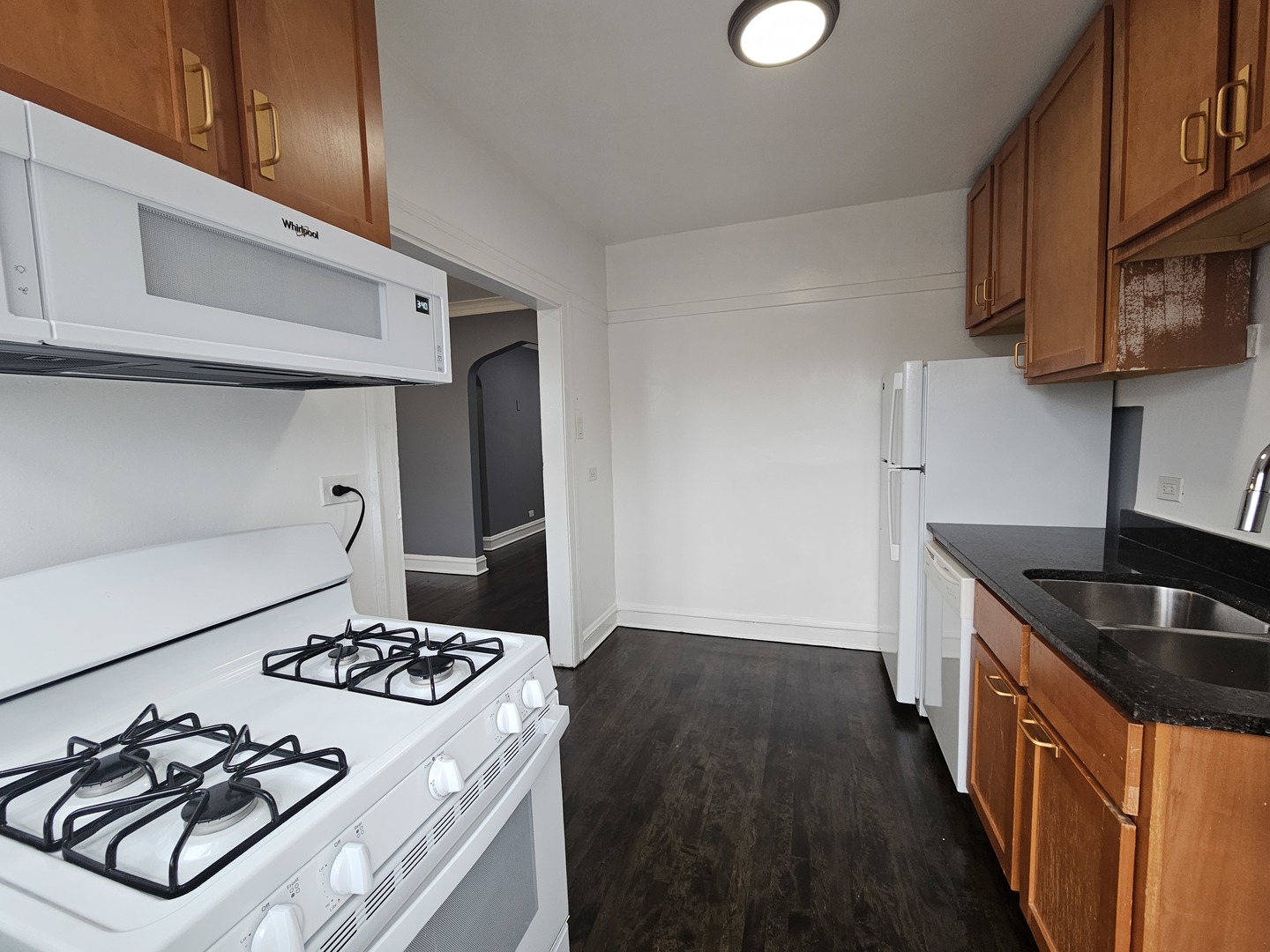 6551 North Francisco Avenue, Unit 3B Chicago, IL 60645 - Photo 9 of 15 a kitchen with granite countertop a sink stove and cabinets