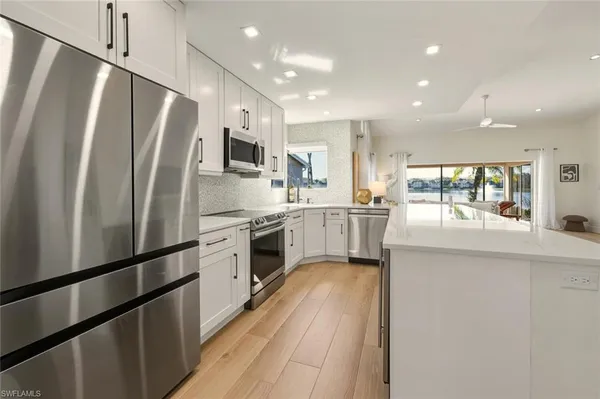 a kitchen with stainless steel appliances a refrigerator sink and microwave