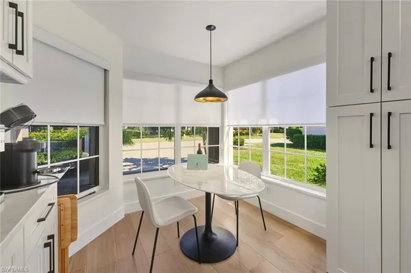 a dining room with furniture large windows and a chandelier