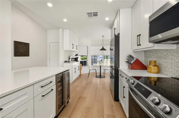 a kitchen with stainless steel appliances granite countertop a sink a stove and a wooden floors