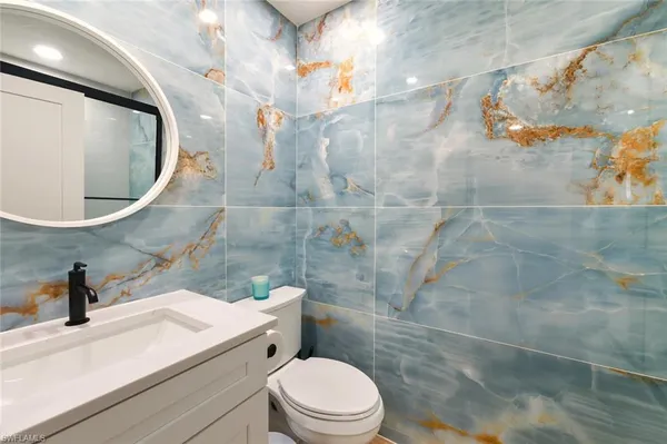 a bathroom with a sink a toilet and a mirror