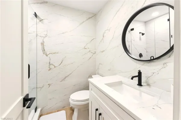a bathroom with a sink a toilet and a mirror