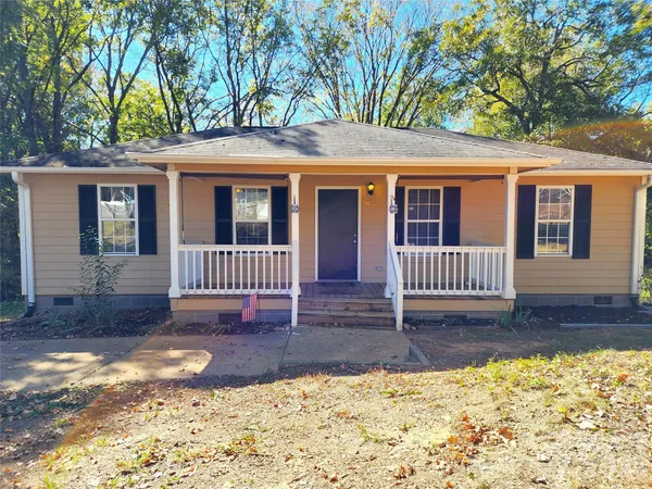 a view of a house with a yard and wooden fence