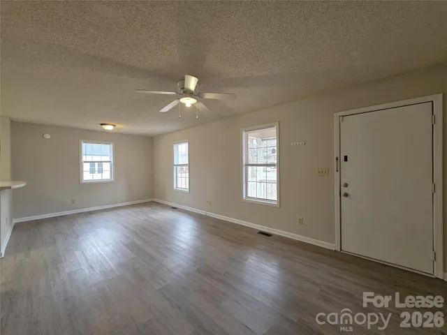 an empty room with wooden floor and window