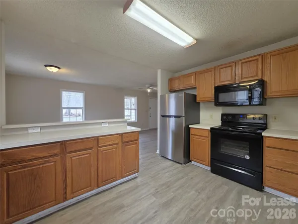 a kitchen with stainless steel appliances granite countertop a stove a sink dishwasher a refrigerator and a microwave oven