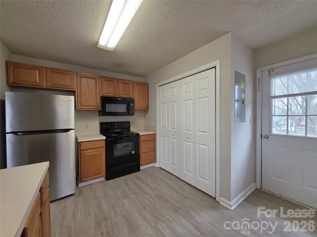 a kitchen with a refrigerator stove and wooden cabinets