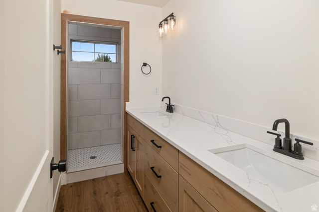 612 North 400 West Logan, UT 84321 - Photo 22 of 27 Bathroom featuring a dual vanity with white countertops, integrated sinks, and matte black fixtures