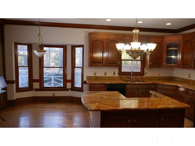 11705 Old Creedmoor Road Raleigh, NC 27613 - Photo 14 of 33 a kitchen with a sink chandelier and wooden floor