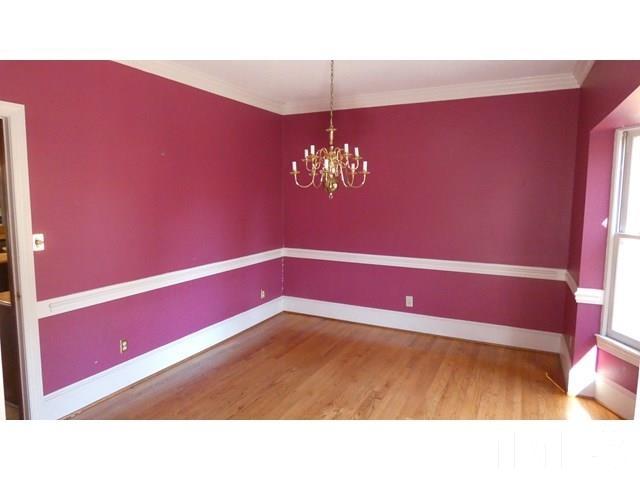 11705 Old Creedmoor Road Raleigh, NC 27613 - Photo 20 of 33 a room with a chandelier fan and wooden floor