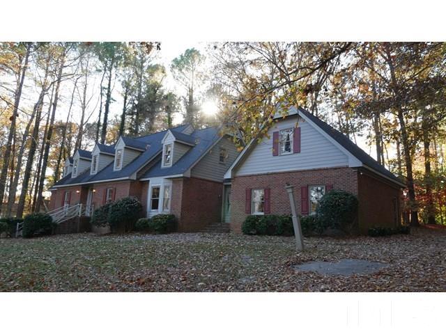 11705 Old Creedmoor Road Raleigh, NC 27613 - Photo 5 of 33 a black and white house with a yard and large trees