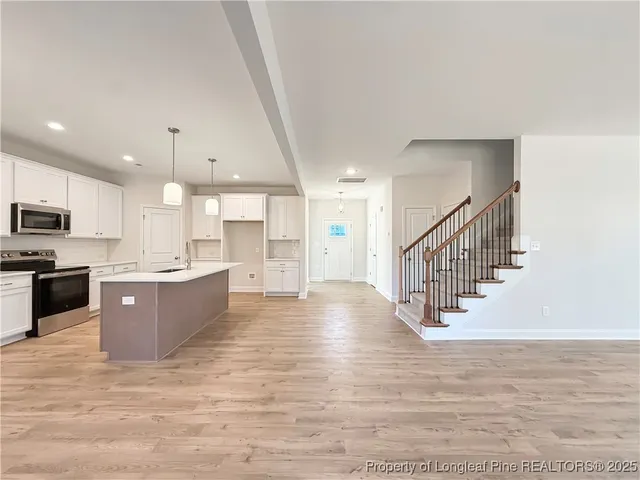 a large kitchen with stainless steel appliances kitchen island granite countertop a stove a sink and a refrigerator