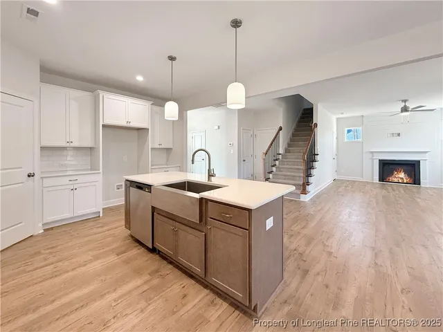 a kitchen with kitchen island a sink a stove and a wooden floors