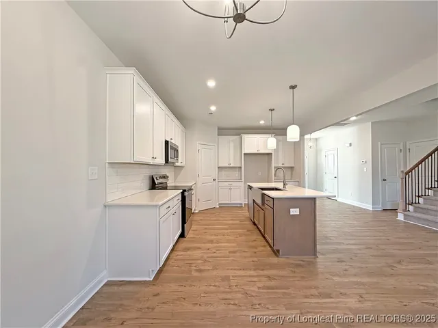 a large kitchen with kitchen island a sink stainless steel appliances and cabinets