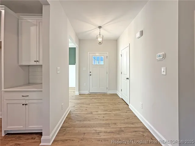 a view of a hallway with wooden floor and closet