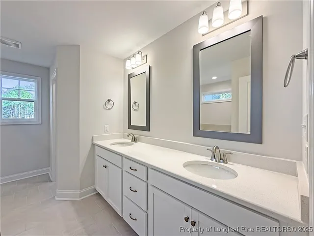 a bathroom with double sink and a mirror