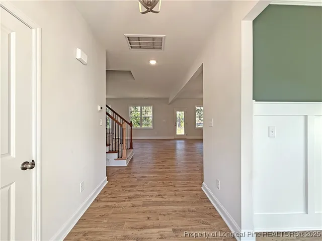 a view of a hallway view with wooden floor and staircase