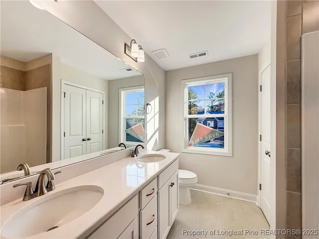 a bathroom with a sink double vanity and a toilet