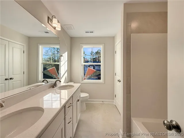 a bathroom with a granite countertop sink a mirror a vanity and a shower