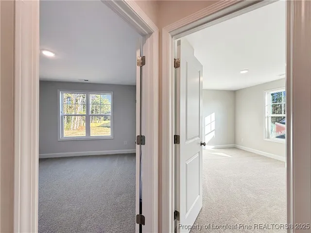 a view of hallway with a large window and chandelier
