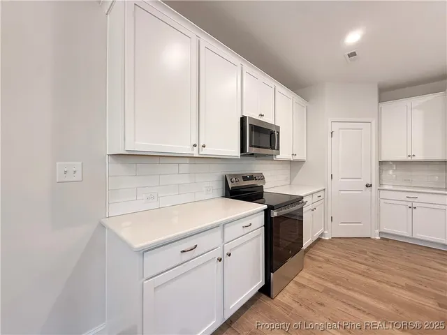 a kitchen with white cabinets appliances and a sink