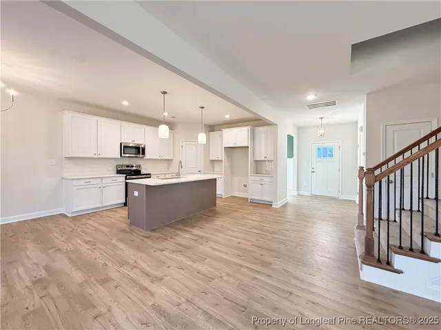 a large kitchen with stainless steel appliances kitchen island wooden cabinets and granite counter tops