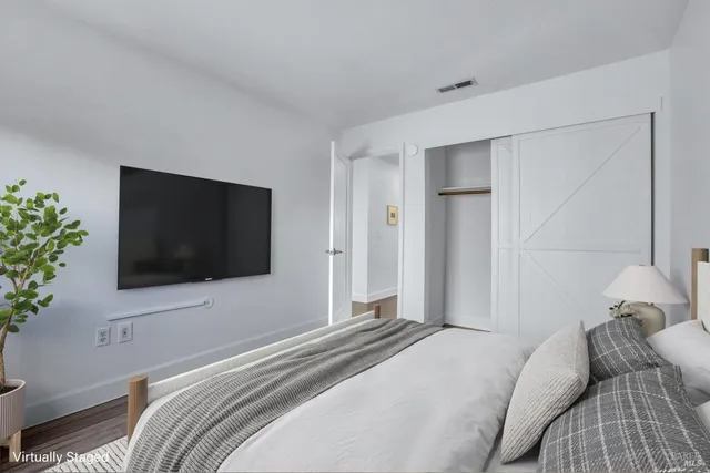 a bedroom with a flat screen tv and a bed