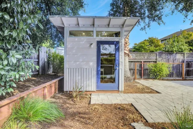 a view of a patio with table and chairs with wooden fence and plants