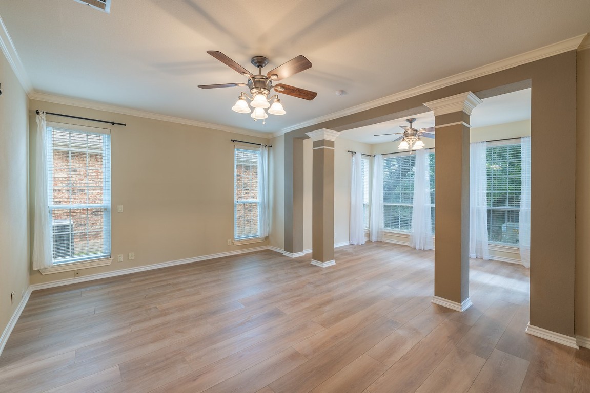 8514 Racine Trail Austin, TX 78717 - Photo 18 of 33 Spare room featuring ornamental molding, ceiling fan, light wood-type flooring, healthy amount of natural light, and ornate columns