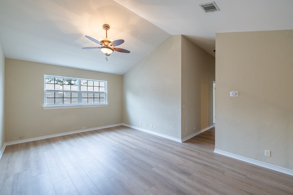 8514 Racine Trail Austin, TX 78717 - Photo 25 of 33 Empty room with light wood-type flooring, a ceiling fan, and lofted ceiling