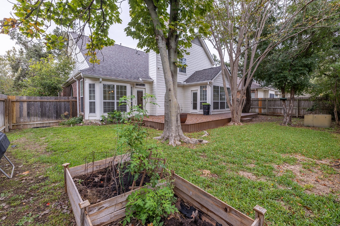 8514 Racine Trail Austin, TX 78717 - Photo 8 of 33 Rear view of property featuring a vegetable garden, a fenced backyard, a wooden deck, roof with shingles, and a chimney
